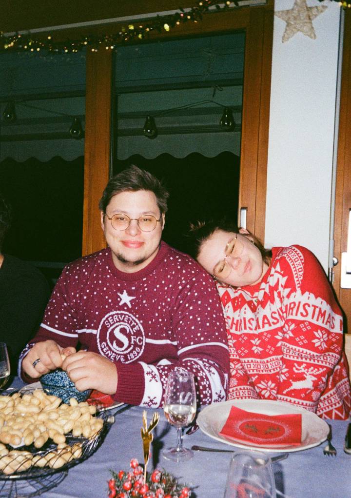 Nous deux à table, en pulls de Noël, sa tête posée sur son épaule.